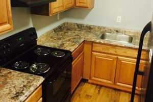 Cary NC Affordable Apartments - Arbors at Cary - Kitchen with Granite Countertops and Wood-Style Cabinets